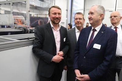 Henning Zeidler von Samasax, Freibergs OB Sven Krüger, Staatsminister Thomas Schmidt und der amtierende Landrat Mittelsachsens Lothar Beier (v. l.) am neuen 3D-Drucker der TU Bergakademie Freiberg.
