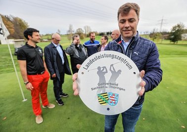Große Freude beim Golfclub Chemnitz über die Einstufung als Leistungszentrum: Vereinschef Axel Wunsch zeigt die offizielle Tafel für das Vereinshaus. Bei der Übergabe war auch Clubmanager Frank Seidel (links) dabei. 
