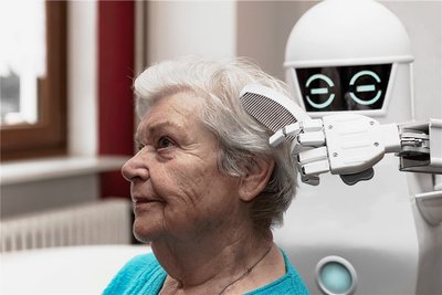 Sieht so die Zukunft aus? Ein Pflegeroboter kämmt einer Seniorin die Haare. Der Einsatz solcher digitalen Assistenzsysteme in der Pflege ist umstritten. 