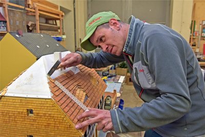 Saisonstart im Klein-Erzgebirge Oederan: Tobias Rickmann bringt am Modell des Heimatmuseums von Neuhausen Hunderte neue Holzdachschindeln an.