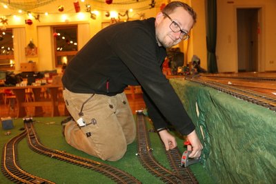 Michael Reuter baut die Gleise für die Gartenbahn mit auf.