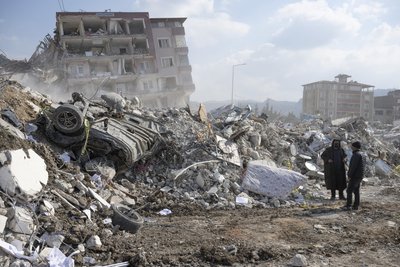 Erdbeben in der Türkei 2023: Anwohner gehen durch Trümmer ihrer Häuser. Die Naturkatastrophe forderte Tausende Todesopfer. Auch Bestatter aus Deutschland halfen bei der Bergung.