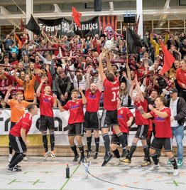 Die Langenauer Landesklasse-Fußballer feiern vor ihrer Fankurve den Sieg des Indoor-Regio-Cups 2022. Von den 900Besuchern war laut Veranstalter rund ein Drittel in rot-schwarzen Farben gekleidet.