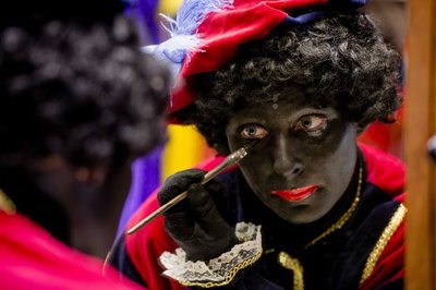 Eine Frau schminkt sich als Zwarte Piet.