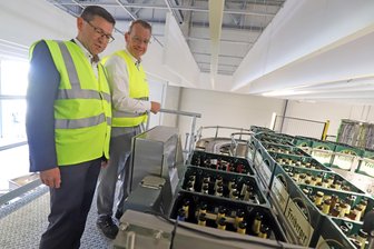 175 Jahre Freiberger Brauhaus: Womit sich das Bier-Unternehmen zum Geburtstag beschenkt - Geschäftsführer Holger Scheich und Landrat Sven Krüger an der neuen Sortieranlage des Freiberger Brauhauses.