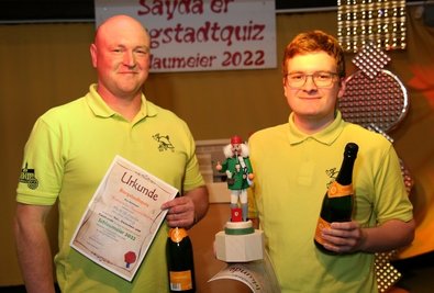 Die Sieger des Schlaumeier-Pokales 2022 in Sayda: Maik Fritzsch (l.) und Markus Härtwig von der Feuerwehrkapelle Friedebach. Der Pokal, ein Räuchermann, wurde eigens für das Quiz vom Saydaer Holzspielzeugmacher Jens-Uwe Werner gefertigt. 