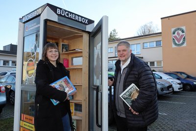 Bücherpatin Jenny Ullmann und Stadtwerke-Chef Sascha Wehrmann an der Bücherbox am Hofgarten in Schwarzenberg.