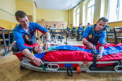 Jürgen Anger (links) und Lukas Anger von der Bergwacht Carlsfeld packen Schüler Louis Müller in den Rettungssack auf der Gebirgstrage.