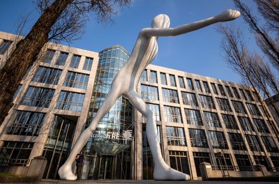 Die Skulptur "Walking Man" vor einem Verwaltungsgebäude der Munich Re. Für den Dax-Konzern liefen die Geschäfte im ersten Quartal erfreulich. (Symbolbild) 