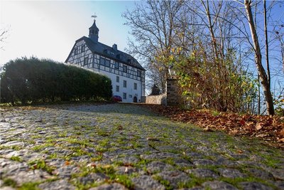 Das Jößnitzer Schloss steht hoch über einer Parkanlage. 