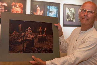Hans-Jürgen Kühn aus Berlin zeigt eines der Bilder von Wolfgang Gröber aus Chemnitz. Die im Edeldruckverfahren entstandenen Arbeiten sind gegenwärtig in der Alten Brauerei zu sehen. Ein immer wiederkehrendes Motiv dabei: Friedhöfe. 