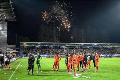 Bezeichnendes Bild nach dem Spiel: Während Darmstadt mit Feuerwerk feiert, werden die Auer Spieler von den Fans beworfen. 