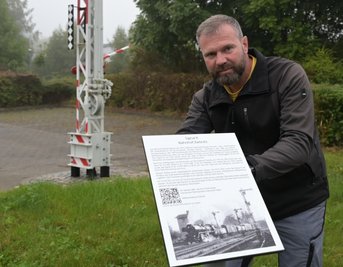 Letzte Handgriffe: Tom Schneider, Leiter des städtischen Bauhofes, überprüft die Festigkeit der neuen Info-Tafel am Bahnsignal. 