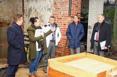 Peggy Wunderlich, Geschäftsführerin der Seidenmanufaktur Eschke (2. v. l.) erklärt Thomas Schmidt (re.) im ehemaligen Wolllager der Tuchfabrik Gebr. Pfau ihr Vorhaben. 