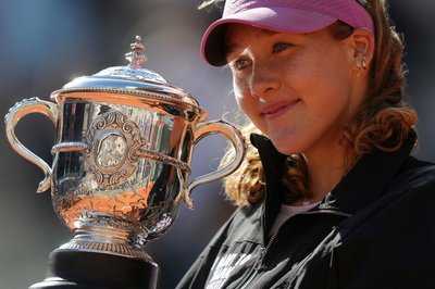 Mirra Andrejewa lächelt mit der Trophäe in den Händen.