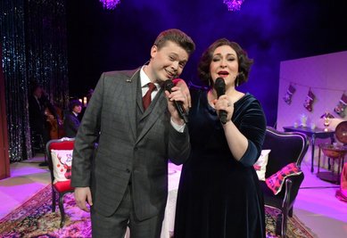 Posieren extra für die Leser der "Freien Presse": Primadonna Leonora Weiß-del Rio und Sänger Dan Smith im Freiberger Theater bei einer Aufzeichnung des Programms "Swinging Christmas", José Luis Gutiérrez (im Hintergrund) agiert bei dem Programm als musikalischer Leiter. 