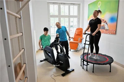 Training mit Sporttherapeut Andreas Grünewald in der Kinderklinik des Klinikums. Borys radelt auf dem Ergometer, Marylou trainiert auf dem Trampolin. 