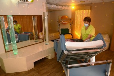 Physiotherapeutin Carolin Herold-Müller im Snoezeleraum mit einer Patientin. Lichteffekte und Klang sind Teil der Entspannungstherapie.