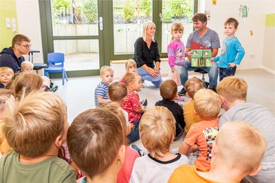 Ingo Krauß nimmt von den Kindern Leo und Maja sowie von Kitaleiterin Katrin Schneider den Erlös des Kuchenbasars entgegen.