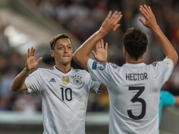Torschütze Mesut Özil (l) klatscht mit Jonas Hector nach dem Treffer zum 1:0 ab.