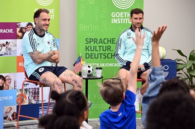 Leon Goretzka (l.) und David Raum (r.) beantworten Fragen von Kindern im Goethe-Institut in Chicago. 