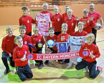 Die Spieler und Betreuer des ESV Lok Chemnitz freuen sich auf das Turnier am Samstag. Hier zeigen sie einige der Fanartikel, die es dabei zugunsten des Elternvereins krebskranker Kinder zu ersteigern gibt. 