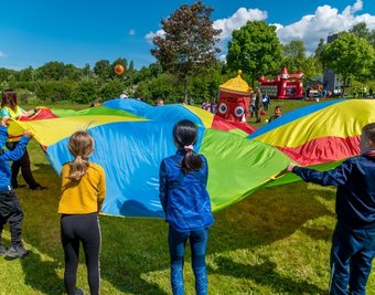 Kinder beim Spiel mit einem Schwungtuch. 1000 Jungen und Mädchen vergnügen sich an verschiedenen Stationen in der Erzgebirgskaserne.