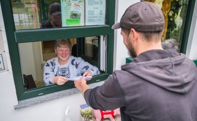 Im Zoo der Minis in Aue erfolgt der Einlass sehr flexibel. Hier nimmt Kassiererin Petra Hörenberg die ausgedruckte Reservierungs-Mail eines Besuchers entgegen. Sie dient der Kontaktnachverfolgung. Wer daheim keinen Drucker hat, kann das Formular auch an der Kasse ausfüllen. 