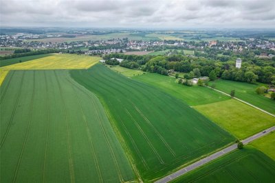 Auf diesem Feld befand sich einst der Flugplatz. In dem Gebäude rechts vor dem Taurasteinturm war ehemals die Flugleitung, das weiße Gebäude im Hintergrund ist die Flugzeughalle.