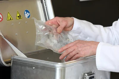 Hat Pharmazie-Ingenieurin Zachert einen Beutel mit Infusionslösung fertig hergestellt, kommt er in eine Transportbox.