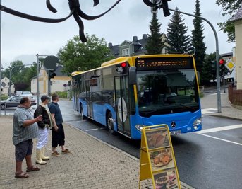 Ein Bus der Linie 53 biegt in die Markersdorfer Straße ein. Wo jetzt der Werbe-Aufsteller steht, gab es bis vor kurzem noch Parkplätze für die Kunden einer Bäckerei und eines Fleischers. Sie klagen nun über Umsatzeinbußen.