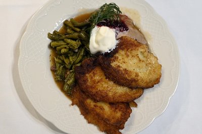 Schwindelbrotn mit Greiselsbeeren und Sahne, dazu gebackene Kließ und Speckbohnen - der zweite Gang des Menüs.