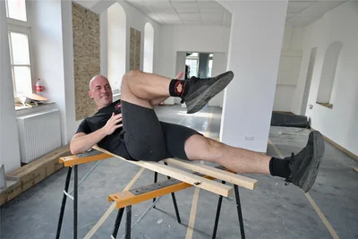 Bis zur Eröffnung am 1. September gibt es im Pilates-Studio noch viel zu tun. Fürs Foto macht sich der Matthias Markstein den Spaß und demonstriert eine Pilatesübung auf den Arbeitsböcken der Handwerker.