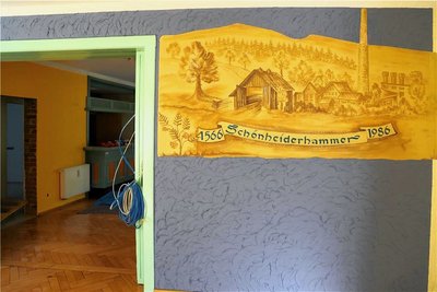 Eines der Wandbilder, die deutlich machen, dass das Haus einmal das Betriebsklubhaus des Schönheider Eisenwerkes war. 