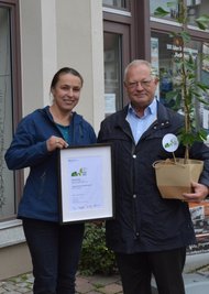 Thomas Firmenich übergibt den zum Preis gehörenden Ginkgo an Jana Hilger. 