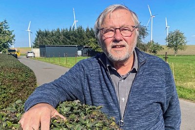 Vater der Windkraft: Michael Heckel auf seinem Grundstück - im Hintergrund der Windpark Sitten mit zwei neuen Windrädern. 