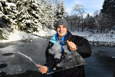 Aaron Curcio vom Landhotel „Altes Zollhaus“ in Neuhermsdorf hält eine dicke Eisplatte in den Händen. Seit Tagen entfernt er immer wieder das Eis vom Badeteich, in dem die Deutschen Meisterschaften im Eisschwimmen stattfinden.