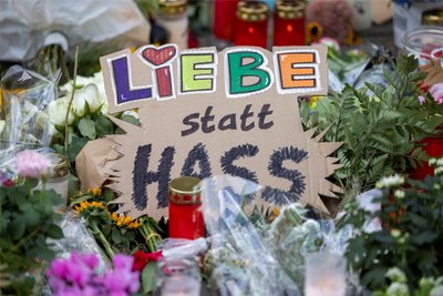 In der Nähe des Tatortes in Solingen, an dem am späten Freitagabend drei Menschen ermordet wurden, haben Menschen Blumen, Kerzen und auf Schilder gemalte Botschaften niedergelegt.