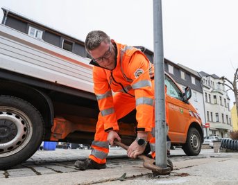 Bauhofmitarbeiter Marcus Grimm stellt auf der Helenenstraße in Limbach-Oberfrohna Verkehrsschilder auf. Das ist eine der vielen Aufgaben, die Straßenwärter übernehmen. 