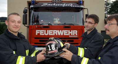 
              <p class="artikelinhalt">Vor der großen Reise nach New York noch ein Fototermin: Oliver Lenk und Sascha Bach gemeinsam mit dessen Vater Uwe Bach (von links) von der Freiwilligen Feuerwehr Sachsenfeld, einem Ortsteil von Schwarzenberg. Der amerikanische Helm ist der ganze Stolz von Oliver Lenk.</p>
            