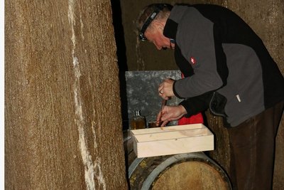 Wolfgang Lückert entnimmt den zwei eingelagerten Fässern Kostproben.