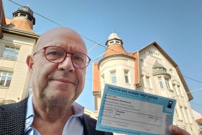 Stefan Tschök, Buchautor und Rezensent des Freiberger Stücks in Leipzig, mit der Eintrittskarte vor dem Theater der Jungen Welt, dem Spielort in der Messestadt.