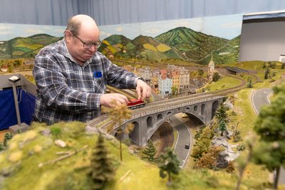 Vereinsmitglied Erik Müller setzt eine Lok aufs Gleis. An die 50 Züge verkehren auf der 40 Quadratmeter großen Anlage. Foto: Ronny Küttner
