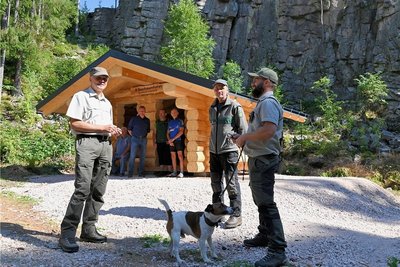 An den Teufelssteinen im Steinbachtal ist eine neue Blockhütte errichtet worden - im Bild vorn (von links) Stephan Schusser, Leiter des Forstbezirkes Eibenstock, Claus Mittag, Revierleiter in Johanngeorgenstadt, und Waldpädagoge Michael Pfalz. 