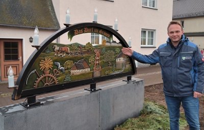 Niederdorfs Bürgermeister Stephan Weinrich am Schwibbogen vorm Schnitzerheim. 
