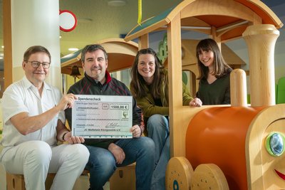 Chefarzt Dr. med. Ulf Meyer nimmt den Scheck von Michael Köhler, Birgit Friedrich und Jennifer Groß (v. l.) entgegen. Mit der Spendensumme soll unter anderem die Eisenbahn auf der Kinder- und Jugendstation des Erzgebirgsklinikums in Annaberg überholt werden.