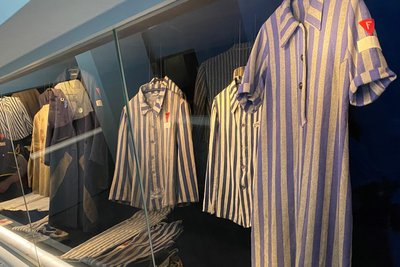 In den Vitrinen werden Häftlingskleidung und Schuhe ausgestellt.
