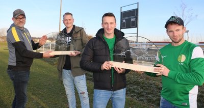 Der Mühltroffer Kapitän, Christoph Bär (rechts), überreicht Tim Neumeister und André Remmer vom VfB Pausa (links), an Felix Schinkitz den Pausa-Mühltroff-Schwibbogen. Im Hintergrund die neue Anzeigetafel. 