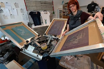 Grafikerin Peggy Albrecht bei der Einrichtung des Siebdruck-Karussells für das Bedrucken von Textilien. 