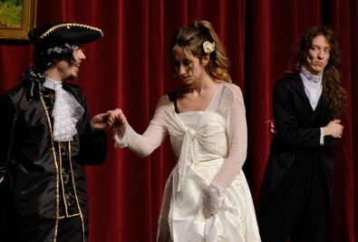 Der in schwärmerischer Naivität befangene Prinz Gonzaga (Marco Teichmann) mit der ebenso schönen wie tugendhaften Emilia Galotti (Ann-Kathrin Thalwitzer). Der intrigante Kammerherr Marinelli (Jakob Seidel/rechts) beobachtet die Szene. 